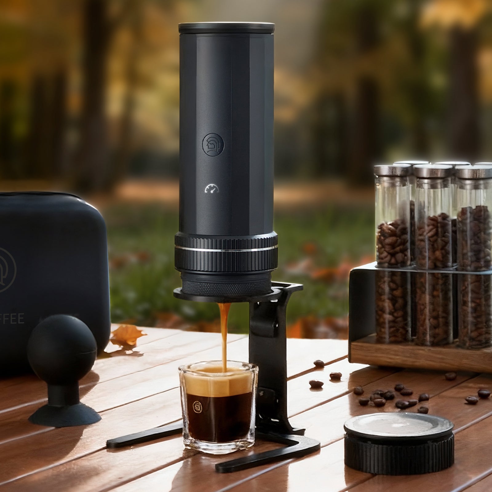 Portable espresso maker brewing fresh coffee into a glass cup outdoors with coffee beans
